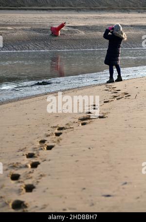 Ebbe am Eingang zu den Brunnen Hafen norfolk england mit Frauen durch Ferngläser schauen Stockfoto