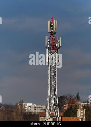 Bild eines Kommunikationsturms auf dem Dach des Gebäudes unter dem blauen Himmel Stockfoto