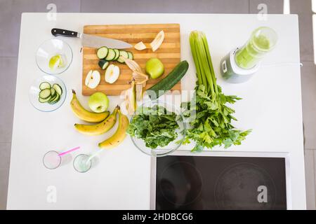 Blick von verschiedenen frischen Früchten und Gemüse mit Schneidebrett auf Kücheninsel Stockfoto