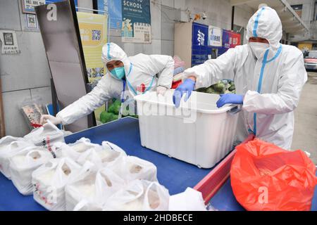 (220105) -- XI'AN, 5. Januar 2022 (Xinhua) -- Freiwillige verpacken Lebensmittel für die Lieferung in der Gemeinschaftsküche Deshan im Bezirk Yanta in Xi'an, nordwestlich der chinesischen Provinz Shaanxi, 4. Januar 2022. Deshan, eine Gemeinschaftsküche im Bezirk Yanta von Xi'an, wurde als „krebsbekämpfende Küche“ geführt und bietet Krebspatienten und ihren Familien die Möglichkeit, Mahlzeiten zuzubereiten. Xu Kai, der Gründer der Gemeinschaftsküche, verwandelte diese „krebsbekämpfende Küche“ in eine „Kampf-gegen-Epidemie-Küche“, nachdem die Stadt vor kurzem vom Wiederaufleben des COVID-19 getroffen wurde. Bisher haben sich mehr als 30 Freiwillige dem Food Delive angeschlossen Stockfoto