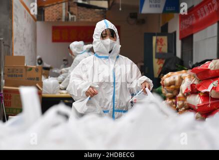 (220105) -- XI'AN, 5. Januar 2022 (Xinhua) -- Freiwillige verpacken Lebensmittel für die Lieferung in der Gemeinschaftsküche Deshan im Bezirk Yanta in Xi'an, nordwestlich der chinesischen Provinz Shaanxi, 4. Januar 2022. Deshan, eine Gemeinschaftsküche im Bezirk Yanta von Xi'an, wurde als „krebsbekämpfende Küche“ geführt und bietet Krebspatienten und ihren Familien die Möglichkeit, Mahlzeiten zuzubereiten. Xu Kai, der Gründer der Gemeinschaftsküche, verwandelte diese „krebsbekämpfende Küche“ in eine „Kampf-gegen-Epidemie-Küche“, nachdem die Stadt vor kurzem vom Wiederaufleben des COVID-19 getroffen wurde. Bisher haben sich mehr als 30 Freiwillige dem Food Delive angeschlossen Stockfoto