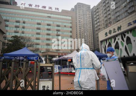 (220105) -- XI'AN, 5. Januar 2022 (Xinhua) -- Ein Freiwilliger liefert einer Krankenschwester im Krebskrankenhaus der Provinz Shaanxi im Bezirk Yanta von Xi'an, nordwestlich der chinesischen Provinz Shaanxi, Nahrung, 5. Januar 2022. Deshan, eine Gemeinschaftsküche im Bezirk Yanta von Xi'an, wurde als „krebsbekämpfende Küche“ geführt und bietet Krebspatienten und ihren Familien die Möglichkeit, Mahlzeiten zuzubereiten. Xu Kai, der Gründer der Gemeinschaftsküche, verwandelte diese „krebsbekämpfende Küche“ in eine „Kampf-gegen-Epidemie-Küche“, nachdem die Stadt vor kurzem vom Wiederaufleben des COVID-19 getroffen wurde. Bisher haben sich mehr als 30 Freiwillige der Th angeschlossen Stockfoto