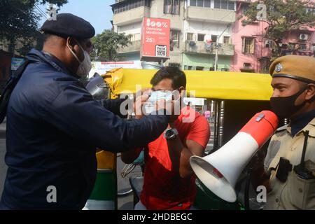 Kalkutta, Indien. 05th Januar 2022. Die Polizei ergreift Maßnahmen gegen Menschen, die die Covid-19-Protokolle nicht befolgen. Die meisten Menschen tragen keine Masken. Es verursacht eine zunehmende Anzahl von Covid- und Omicron-Fällen. Aus diesem Grund sind sich die Polizei der Menschen vor Ort, der Fahrgäste, der Busleiter und der Autofahrer bewusst und verteilen Masken. Indiens frische Covid-19-Fälle haben die 50.000-in-a-Day-Marke überschritten, wobei mehrere Staaten wie Maharashtra, Delhi, Westbengalen, Karnataka und Tamil Nadu einen Anstieg ihrer frischen Infektionen berichteten. (Foto von Rahul Sadhukhan/Pacific Press) Quelle: Pacific Press Media Production Corp./Alamy Live News Stockfoto