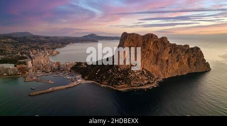 Malerischer mehrfarbiger Sonnenaufgang über Calpe und Penyal d IFAC Natural Park. Horizont über den Gewässern der ruhigen Mittelmeerküste. Reisen und Urlaub Stockfoto