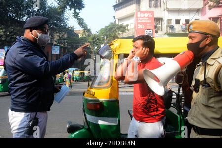 Kalkutta, Westbengalen, Indien. 5th Januar 2022. Die Polizei ergreift Maßnahmen gegen Menschen, die die Covid-19-Protokolle nicht befolgen. Die meisten Menschen tragen keine Masken. Es verursacht eine zunehmende Anzahl von Covid- und Omicron-Fällen. Aus diesem Grund sind sich die Polizei der Menschen vor Ort, der Fahrgäste, der Busleiter und der Autofahrer bewusst und verteilen Masken. Indiens frische Covid-19-Fälle haben die 50.000-in-a-Day-Marke überschritten, wobei mehrere Staaten wie Maharashtra, Delhi, Westbengalen, Karnataka und Tamil Nadu einen Anstieg ihrer frischen Infektionen berichteten. (Bild: © Rahul Sadhukhan/Pacific Press via ZUMA Press Wire) Stockfoto