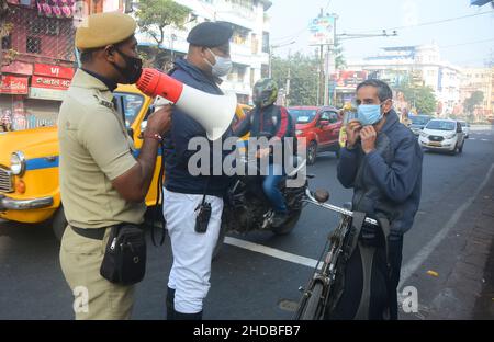 Kalkutta, Westbengalen, Indien. 5th Januar 2022. Die Polizei ergreift Maßnahmen gegen Menschen, die die Covid-19-Protokolle nicht befolgen. Die meisten Menschen tragen keine Masken. Es verursacht eine zunehmende Anzahl von Covid- und Omicron-Fällen. Aus diesem Grund sind sich die Polizei der Menschen vor Ort, der Fahrgäste, der Busleiter und der Autofahrer bewusst und verteilen Masken. Indiens frische Covid-19-Fälle haben die 50.000-in-a-Day-Marke überschritten, wobei mehrere Staaten wie Maharashtra, Delhi, Westbengalen, Karnataka und Tamil Nadu einen Anstieg ihrer frischen Infektionen berichteten. (Bild: © Rahul Sadhukhan/Pacific Press via ZUMA Press Wire) Stockfoto