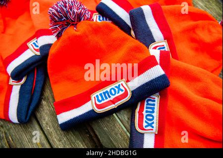 3. Januar 2022, Nijmegen, Gelderland, Niederlande: Ein Blick auf die traditionellen orangefarbenen Beanies von Unox auf einem Holztisch. .Diese Woche ist genau 25 Jahre her als das letzte Elfstedentocht-Event (eine fast 200 Kilometer lange Langstrecken-Tour-Skating-Veranstaltung auf Natureis). Es war auch der Tag, an dem die Niederlande erstmals die orangene Eislaufmütze aus Unox kennenlernten. Im Laufe der Jahre wurden Hunderttausende von Unox-Beanies während Winterveranstaltungen an Besucher und Teilnehmer verteilt, wie zum Beispiel beim traditionellen Neujahrstauchgang am Strand von Scheveningen, was diese niederländische Stilikone zu einer Legende macht Stockfoto