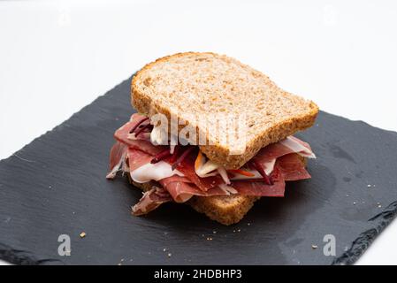 Vollkornbrot-Sandwich mit rohem Schinken und Salat auf weißem Hintergrund Stockfoto