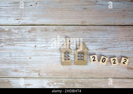 Scheidung, Teilung des Eigentums, Armut und kein Geld Konzept. Holz gebrochenes Haus und Neujahr 2022 Hintergrund. Hypothek, Miete, immobilienmakler Stockfoto