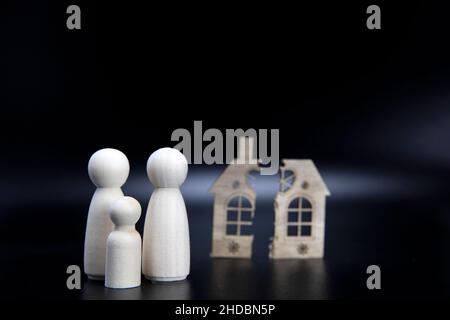 Scheidung, Teilung des Eigentums, Armut und kein Geld Konzept. Holz gebrochenes Haus auf schwarzem Hintergrund. Hypothek, Miete, makler Konzept Kopieplatz Stockfoto