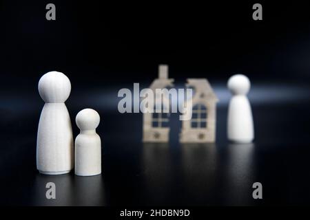 Scheidung, Teilung des Eigentums, Armut und kein Geld Konzept. Holz gebrochenes Haus auf schwarzem Hintergrund. Hypothek, Miete, makler Konzept Kopieplatz Stockfoto