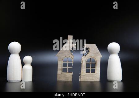 Scheidung, Teilung des Eigentums, Armut und kein Geld Konzept. Holz gebrochenes Haus auf schwarzem Hintergrund. Hypothek, Miete, makler Konzept Kopieplatz Stockfoto