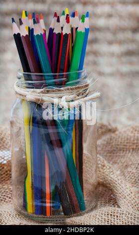 Buntstifte im Glas auf rustikalem Tisch Stockfoto