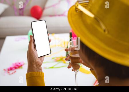 Ältere Frau, die über ein Smartphone telefonieren und Champagner auf der Party zu Hause genießen, Platz kopieren Stockfoto