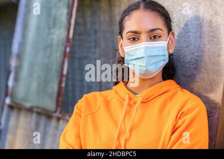 Mädchen Teenager Teenager gemischt Rasse biracial afroamerikanischen Frau junge Frau trägt Gesichtsmaske bei Coronavirus COVID-19 Pandemie Stockfoto