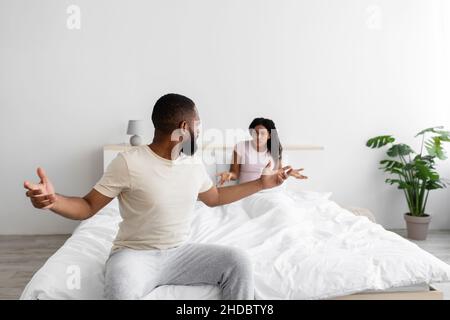 Verzweifelt wütend aufgeregt junge schwarze Frau und Mann ausflippend und schreit, schwören im Schlafzimmer Innenraum, kopieren Raum Stockfoto