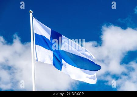 Die finnische Nationalflagge winkt am blauen Himmel. Flagge Finnlands auch Siniristippu genannt. Stockfoto