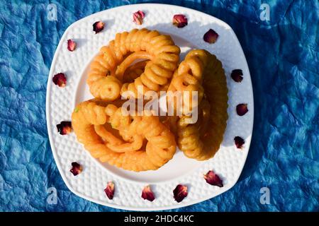 Beliebte indische pakistanische süße Gericht Imarti. Auch bekannt als Amriti oder Omriti ähnlich wie Jalebi mit kreisförmigen Blütenform Design tiefes Braten in Clarifie Stockfoto