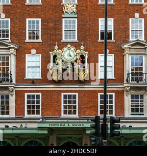 Das legendäre Kaufhaus Fortnum and Mason in London ist berühmt für seine üppigen Ausstellungen und Dekorationen. Draußen an der Fassade tauchen Mr. Fortnum und Mr. Mason um vier Uhr scharf als fast lebensgroße Holzfiguren aus der Musikbox auf, tragen ein Teeset und, in Anspielung auf die frühen Tage, einen Kerzenständer, Sich höflich verbeugen und so jeden Besucher des Fortnum & Mason Stores spielerisch verzaubern. City of Westminster, England Stockfoto