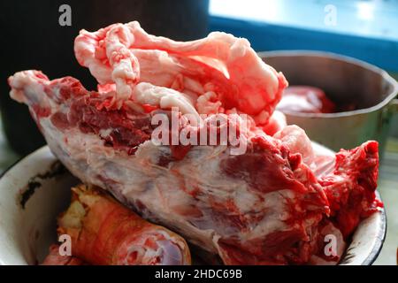 Gehackte Schweineknochen in Aluminiumplatte. Schweinefleisch Konzept Nahaufnahme. Schweinekopf abgehackt. Keine Personen. Farmer-Konzept. Tiermissbrauch. Schweinefleisch. Farmer p Stockfoto