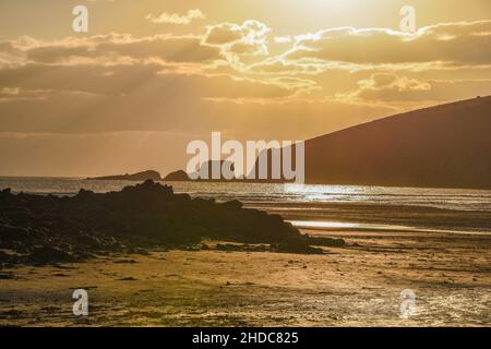 Wonwell Beach bei Sonnenuntergang mit goldenen Wolken Stockfoto