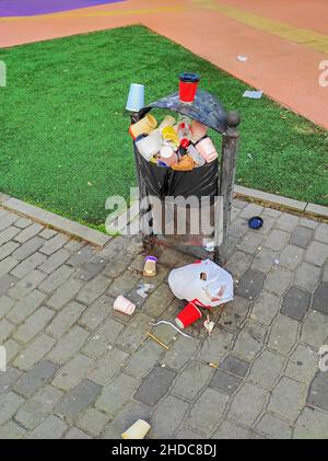 Dnipro, Ukraine - 04. August 2021: Mülltonne überfüllt mit Polyethylenabfällen im öffentlichen Stadtpark Stockfoto