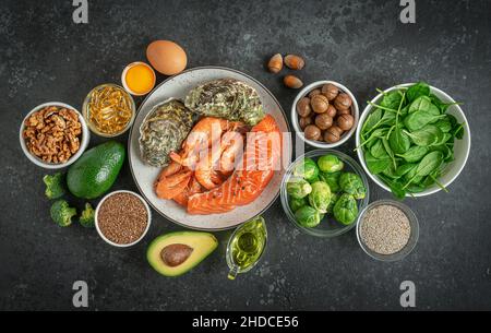 Omega 3 Lebensmittelzusammensetzung auf dunklem Betongrund. Ketogene und paleo Ernährung Konzept. Draufsicht Stockfoto