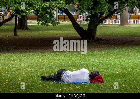 Mann schläft in einem Park (Volksgarten) in Linz, Österreich. Stockfoto