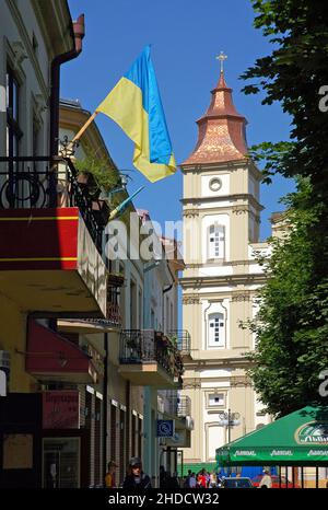 Ivano Frankivsk, Ukraine: Die Kathedrale der Heiligen Auferstehung vom Rynok-Platz im Zentrum von Ivano Frankivsk aus gesehen. Ukraine Flagge im Vordergrund. Stockfoto