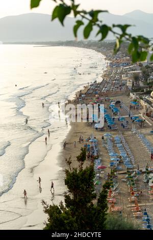 Blick auf den Sandstrand von Sperlonga und Touristen bei Sonnenuntergang, alte italienische Stadt in der Provinz Latina am Tyrrhenischen Meer, Touristen Urlaubsziel Stockfoto