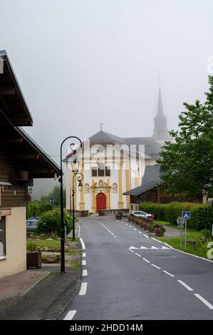 Blick auf die Bergkapelle in einem nebligen kleinen Dorf in der Nähe von Saint-Gervais-les-Bains, Savoyen, Frankreich im Sommer Stockfoto
