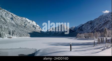 Frisch verschneite und gefrorene heiterwangersee an einem herrlich sonnigen Wintertag mit blauem Himmel Stockfoto