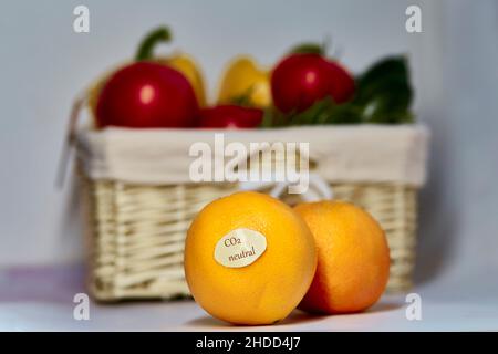 CO2 neutrales Etikett auf Orangen. CO2-Kennzeichnung. Netto kohlenstofffrei, emissionsfrei. Korbkorb mit klimaneutralem Produktlabel auf frischem Gemüse. Bio-Landwirtschaftsprodukte vom lokalen Markt Stockfoto