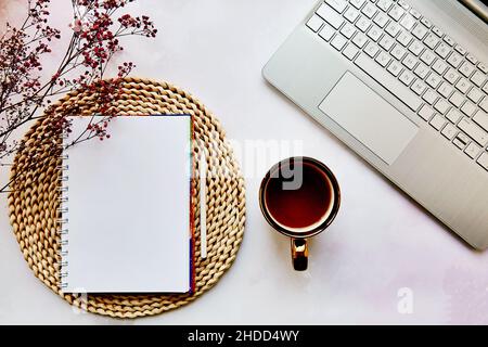 Aufgestellte Notizblock, Laptop, Teetasse und Gypsophila-Blume. Liste der Ziele, zu tun Liste Konzept. Gemütliche Wohnästhetik. Speicherplatz kopieren. Blick von oben. Stockfoto