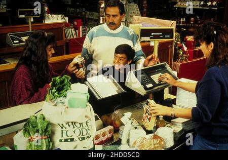 Austin Texas USA, um 1990: Hispanische Familie an der Kasse des örtlichen Reformhauses Whole Foods. HERR ES-0437. ©Bob Daemmrich Stockfoto