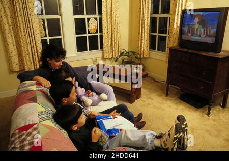 Austin Texas USA,1995: Alleinerziehende Mutter mit zwei Kindern, die nachts zu Hause Fernsehen. HERR EC-031 ©Bob Daemmrich Stockfoto