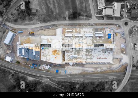 Luftaufnahme einer großen Baustelle für eine Industriehalle mit schwarz-weißer Umgebung Stockfoto