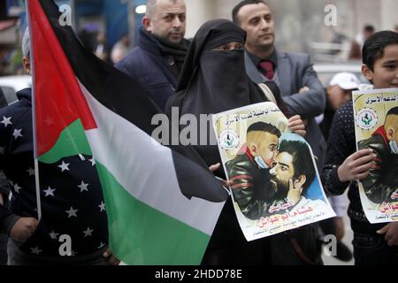 Nablus, Palästina. 05th Januar 2022. Der Palästinenser hält ein Plakat des palästinensischen Gefangenen Hisham Abu Hawasch, der sich 141 Tage lang in israelischen Gefängnissen im Hungerstreik befindet. Kredit: SOPA Images Limited/Alamy Live Nachrichten Stockfoto