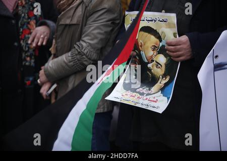 Nablus, Palästina. 05th Januar 2022. Der Palästinenser hält ein Plakat des palästinensischen Gefangenen Hisham Abu Hawasch, der sich 141 Tage lang in israelischen Gefängnissen im Hungerstreik befindet. (Foto von Nasser Ishtayeh/SOPA Images/Sipa USA) Quelle: SIPA USA/Alamy Live News Stockfoto