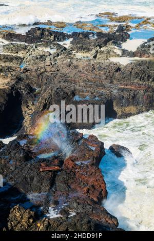 Prismatischer Regenbogen in abstürzenden Wellen; Devils Churn & Spouting Horn; Pazifischer Ozean; südlich von Yachats; Oregon, USA. Stockfoto