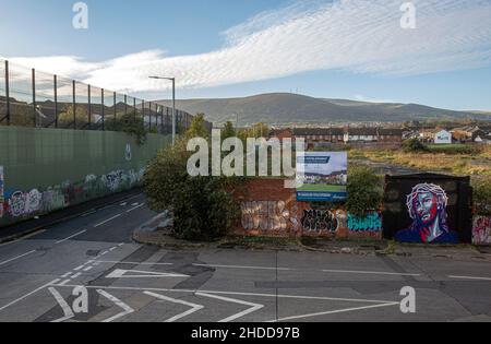 Bunte Wandgemälde und Graffiti auf der Peace Wall oder Peace Line, die entlang des Cupar Way in Belfast verläuft. Es ist eine der vielen Trennbarrieren in Northern Irel Stockfoto