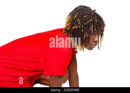 Schöne junge Frau in roten Kleidern und sitzend. Stockfoto