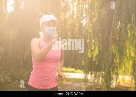 COVID-19. Frau s geht während einer Pandemie auf einem Straßensportplatz Sport. Coronavirus in Europa. Stockfoto