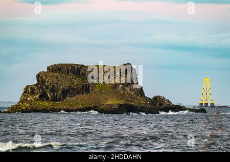 Firth of Forth, Schottland, 5th. Januar 2022. Wetter in Großbritannien: Bei Sonnenuntergang fährt ein Lastkahn mit einer riesigen Windturbinenplattform zur Nordsee, vorbei an Fidra Island Stockfoto