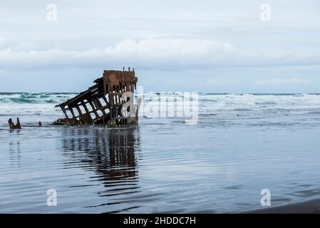 Die Wellen des Pazifischen Ozeans schlagen sich gegen die Schiffbrüchigen Peter Iredale, Fort Stevens State Park, Hammond, Oregon, USA Stockfoto