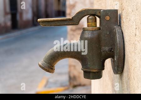 Nahaufnahme eines alten Wasserhahns an der Wand Stockfoto