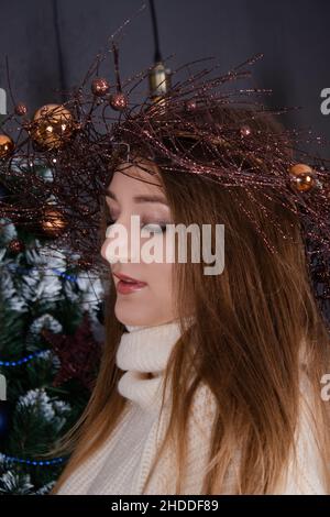 Happy Charming hübsche Frau in gemütlichen beige Strickpullover in der Nähe von weihnachtsbaum. Neujahr Thema. Millennials. Stockfoto