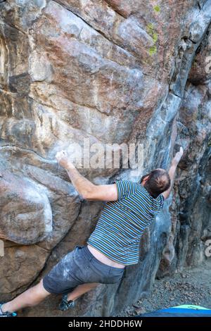 Golden, Colorado - Ein Mann arbeitet an seinen Boulderfähigkeiten an Felsen im Clear Creek Canyon. Stockfoto