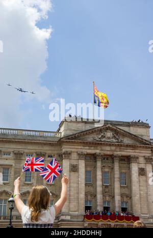 RAF Battle of Britain Memorial Flug über Buckingham Palace, London mit einem jungen Mädchen, das die Union Flags winkt. Queen und Royal Family auf Balkon 2009 Stockfoto