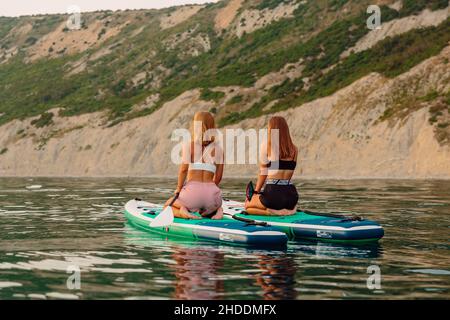 25. Juni 2021. Anapa, Russland. Schlanke Mädchen auf Stand-up-Paddle-Board auf ruhiger See. Frau auf dem Red Paddle SUP Board im Meer. Stockfoto